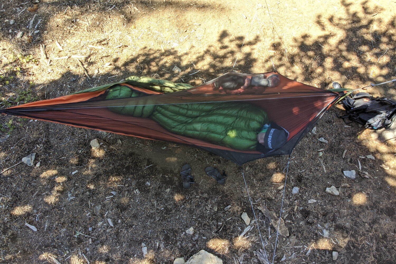 A hiker laying in a backpacking hammock