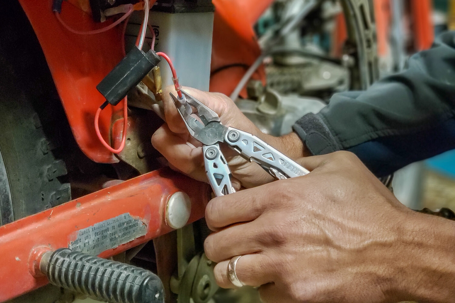 person working on electrical wires with a multitool
