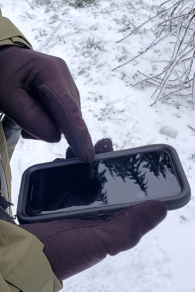 Closeup-of-someone-using-a-phones-touchscreen-with-gloved-hands