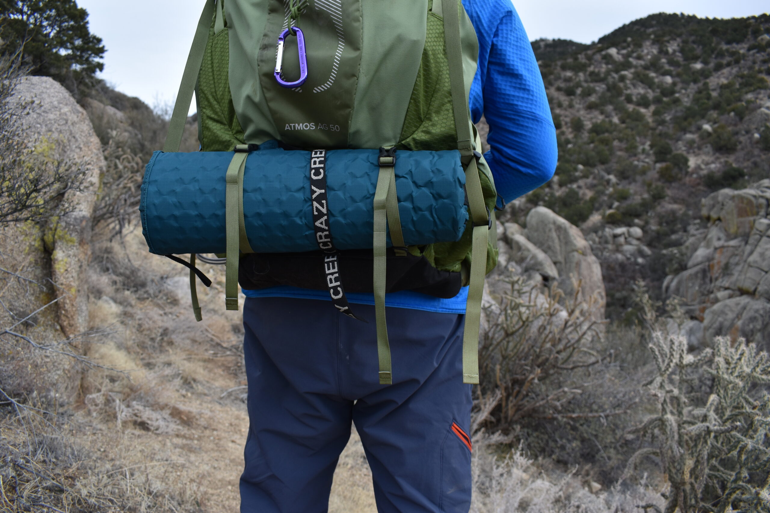 Close up of the Hex 2.0 rolled up and strapped to the bottom of a 50 L backpack