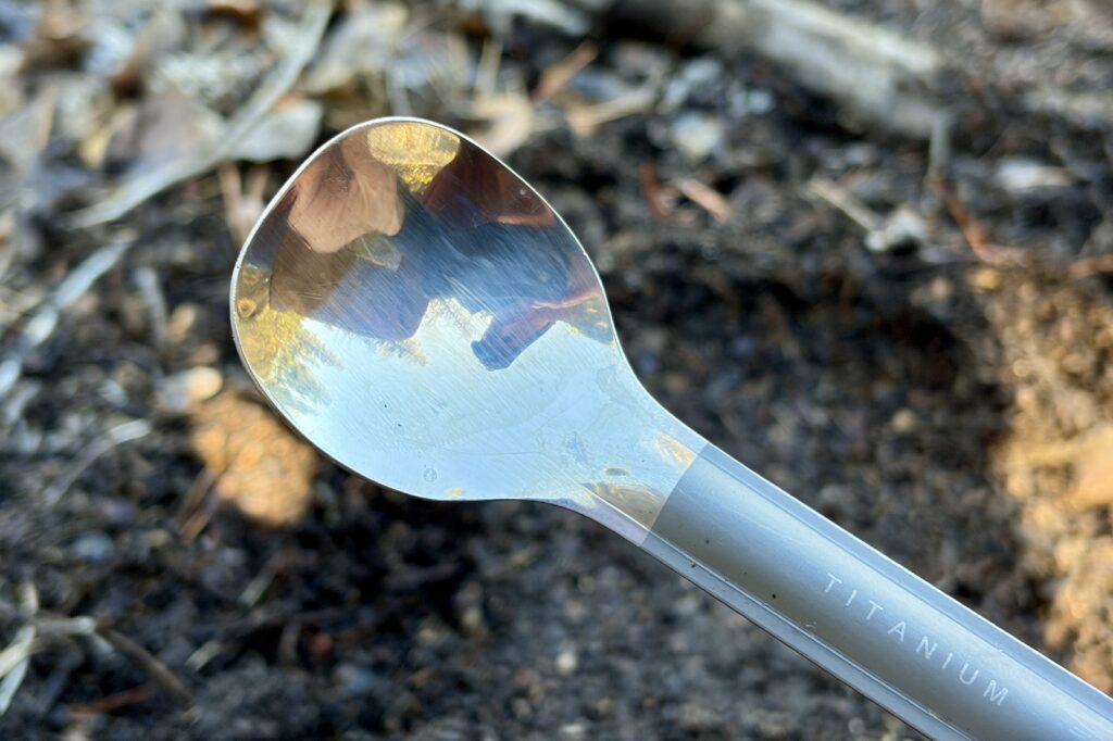 a close up of the polished spoon on a titanium long handle spoon