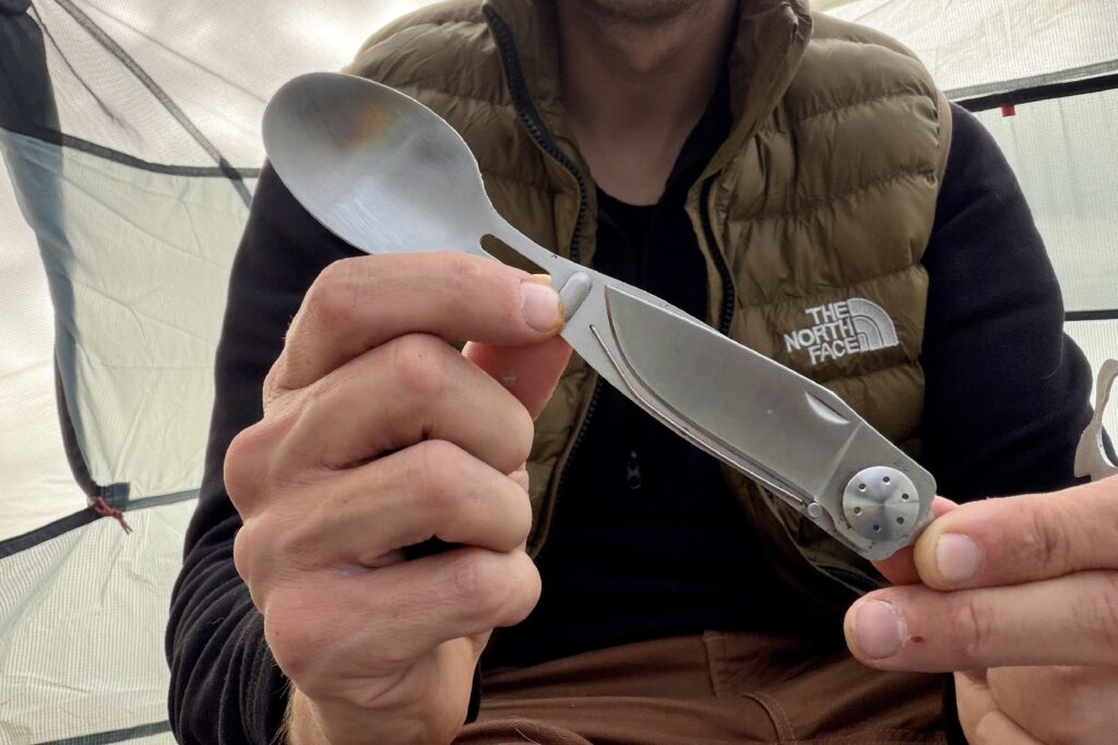 a hiker shows a spoon knife combo to the camera