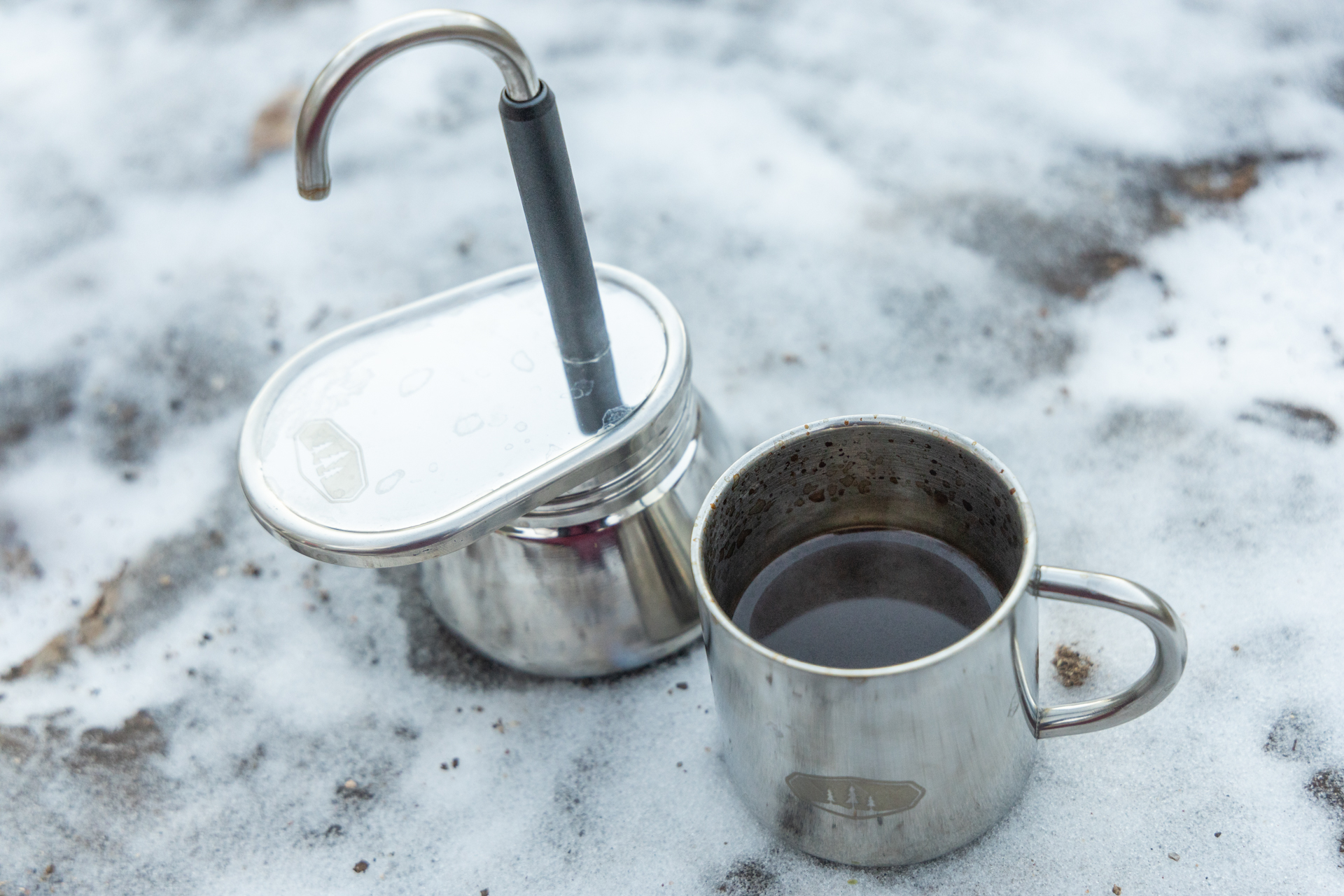 A small cup full of coffee from next to the GSI Mini Espresso.