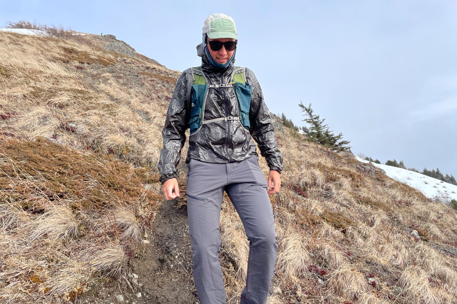 A man hikes down a steep mountain trail.