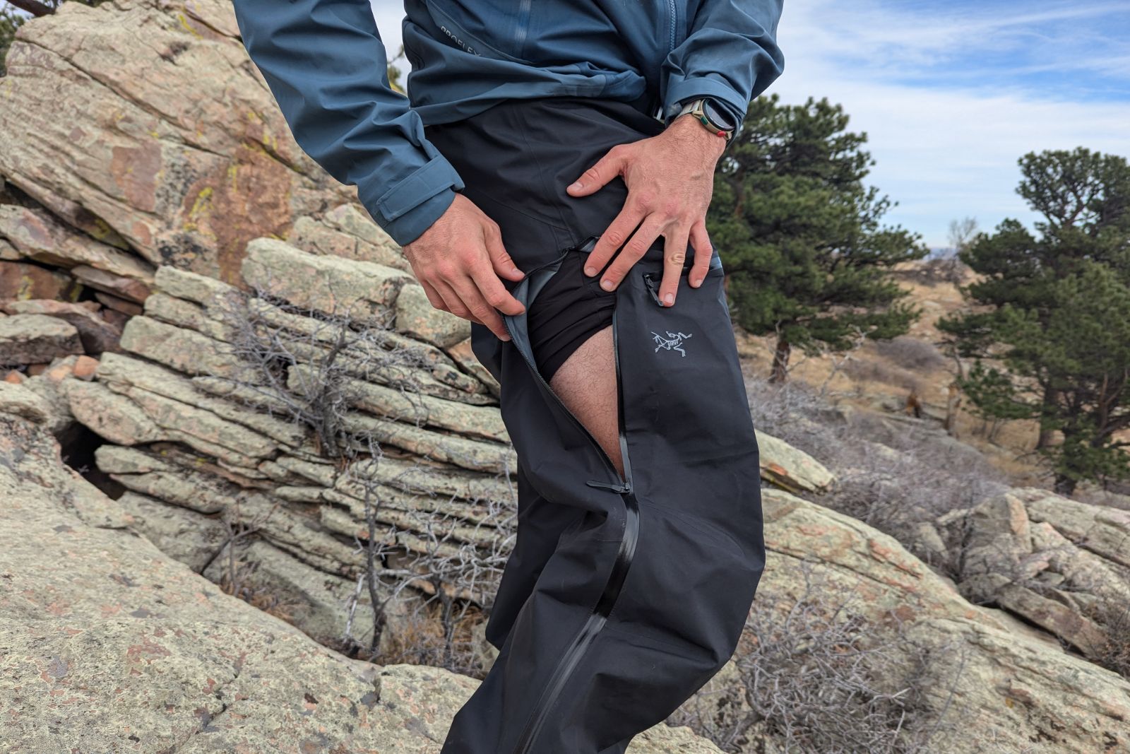 Demonstrating a side-zip ventilation port on the Arc'teryx Beta Pants.