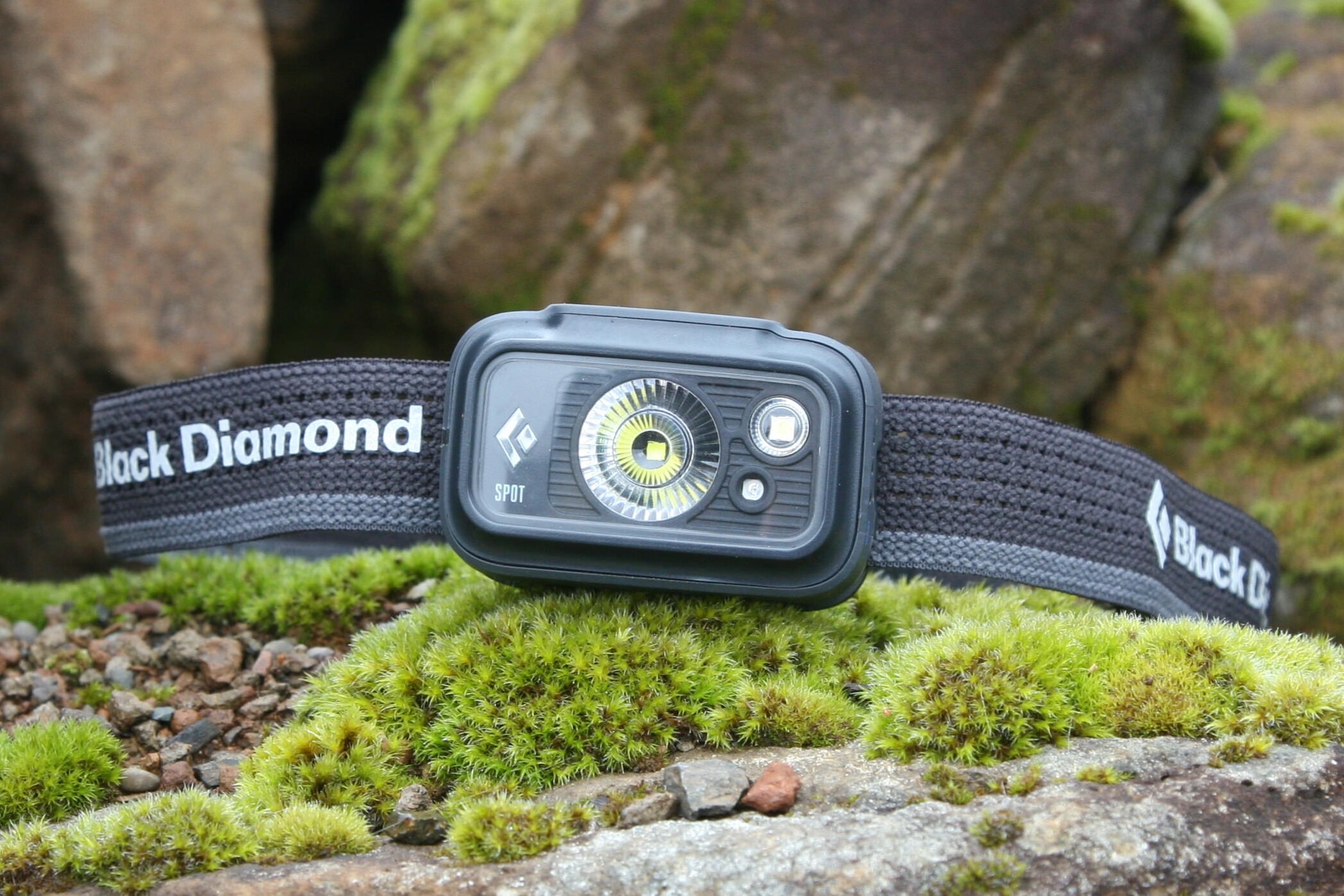 black diamond spot headlamp on a mossy rock